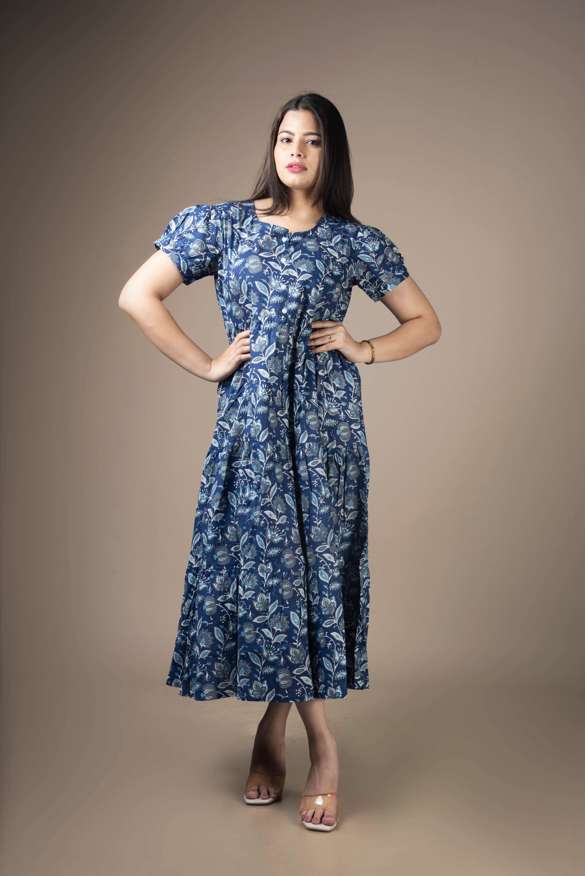 Woman wearing a blue floral dress against a brown background