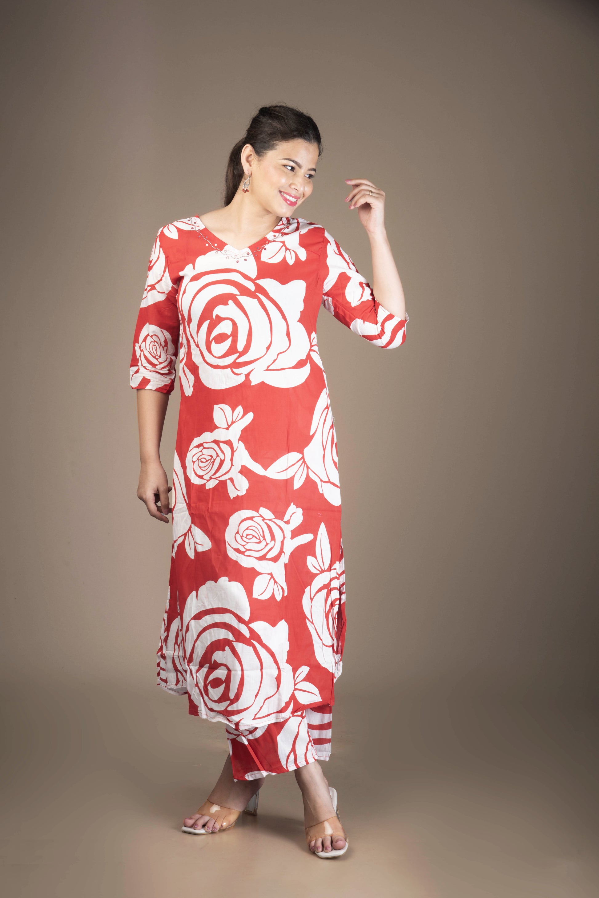 Woman wearing a red dress with white floral patterns on a brown background