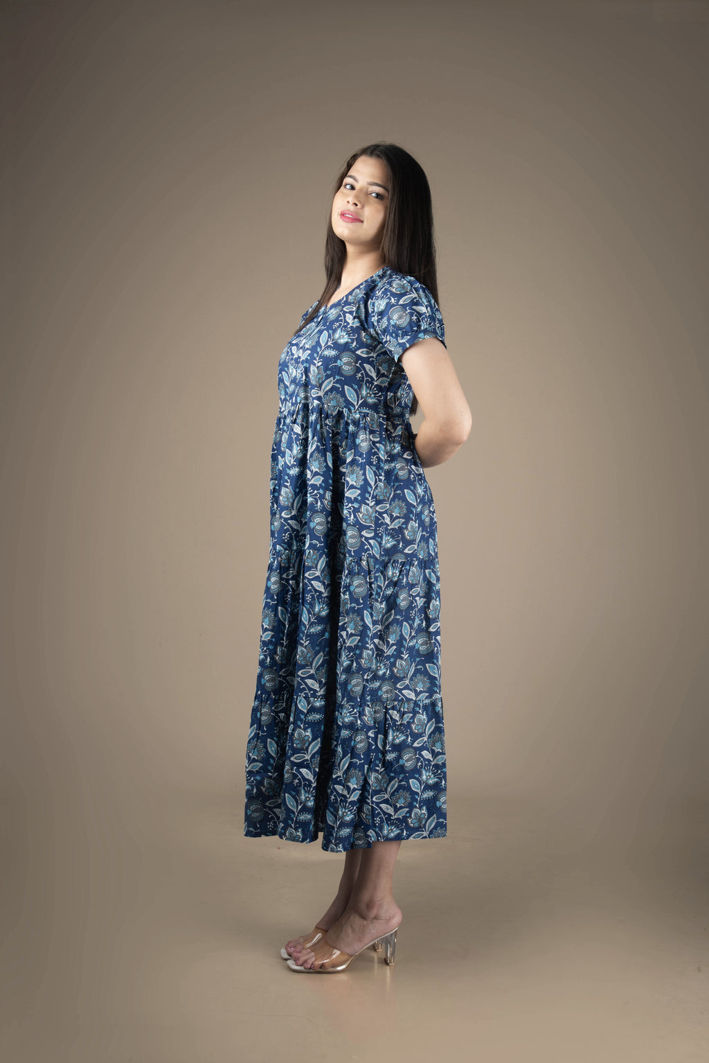 Woman wearing a blue floral dress against a brown background