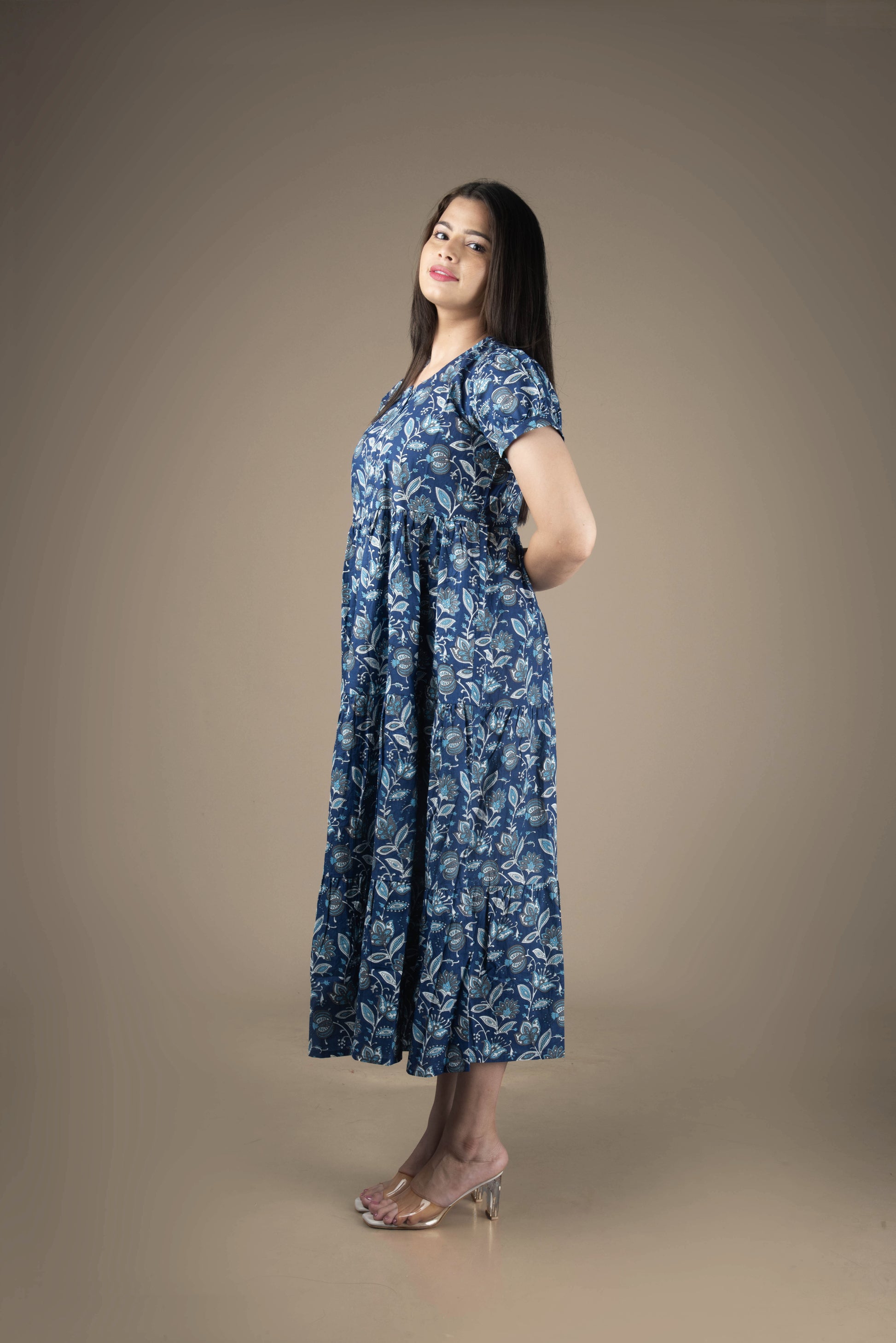 Woman wearing a blue floral dress against a brown background