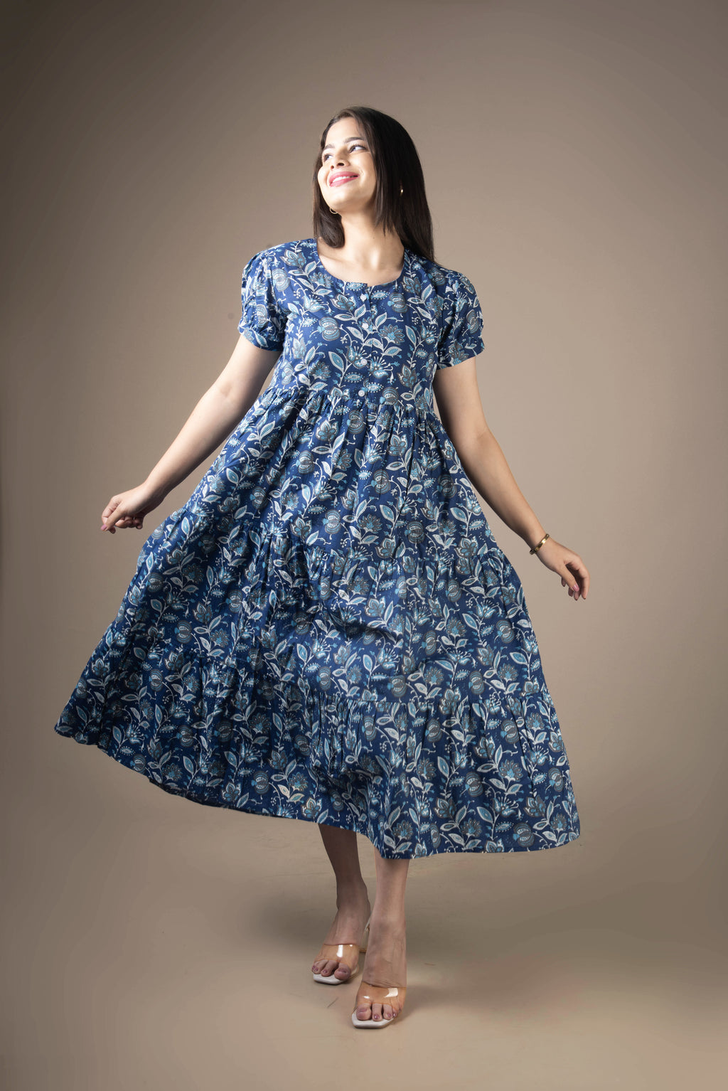 Woman wearing a blue floral dress against a brown background