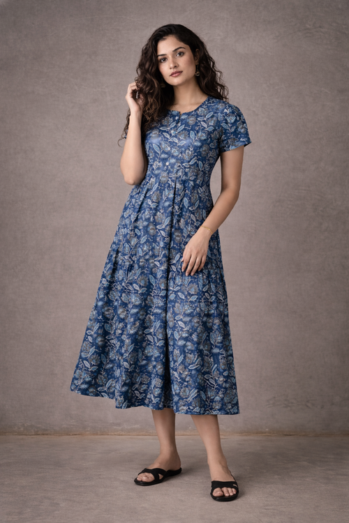 Woman wearing a blue floral dress against a gray background
