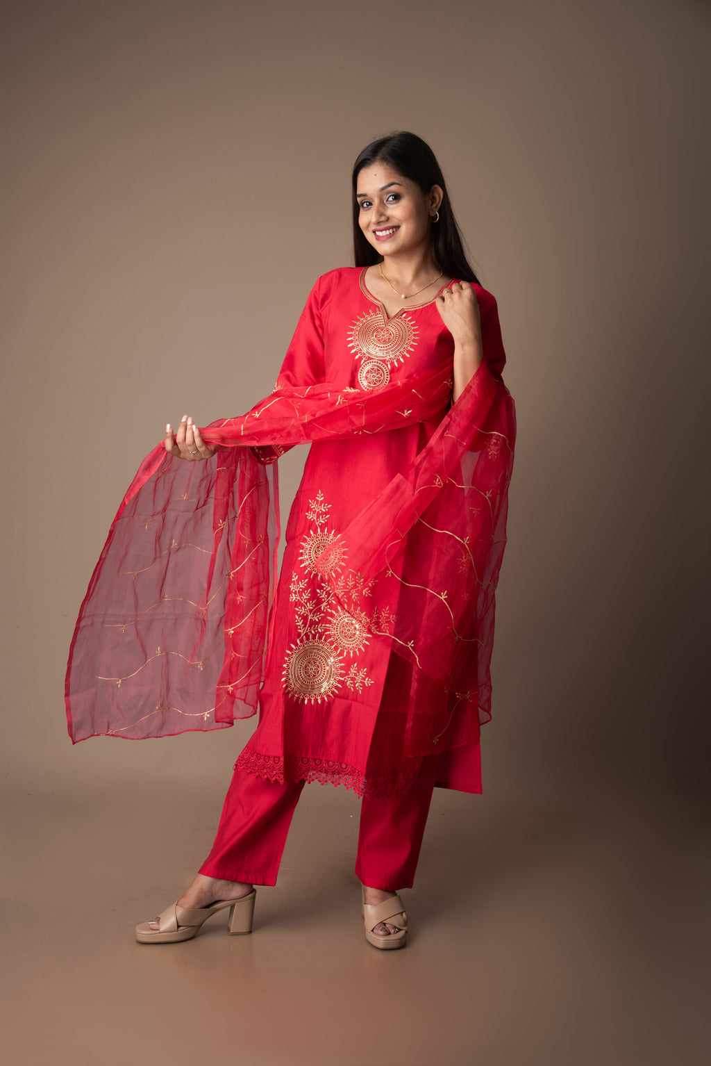 Woman wearing a red traditional outfit with embroidery on a brown background