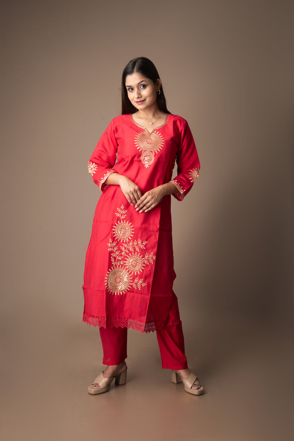 Woman wearing a red embroidered traditional outfit on a brown background