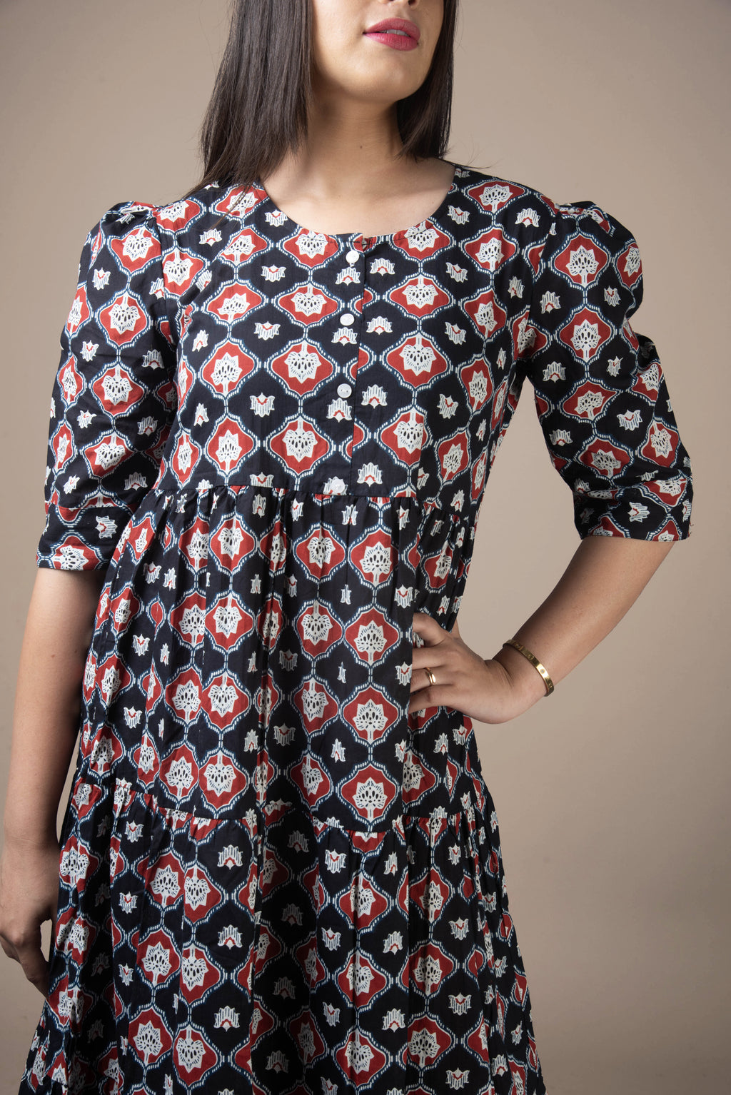 Woman wearing a patterned dress with a neutral background