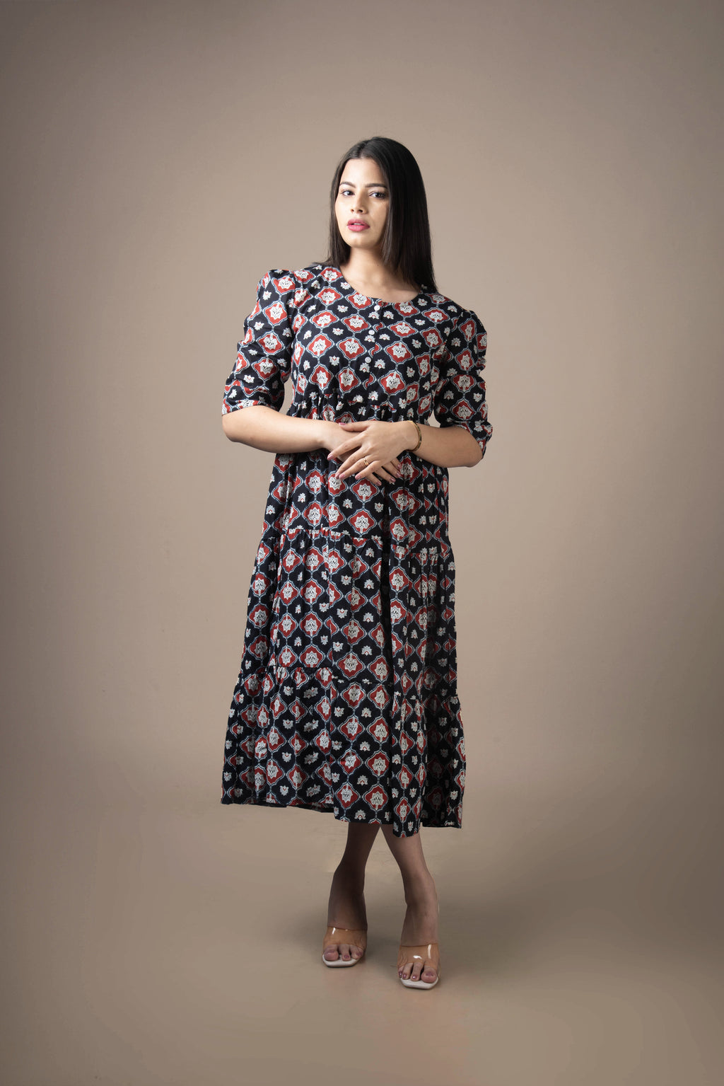 Woman wearing a floral dress against a plain background
