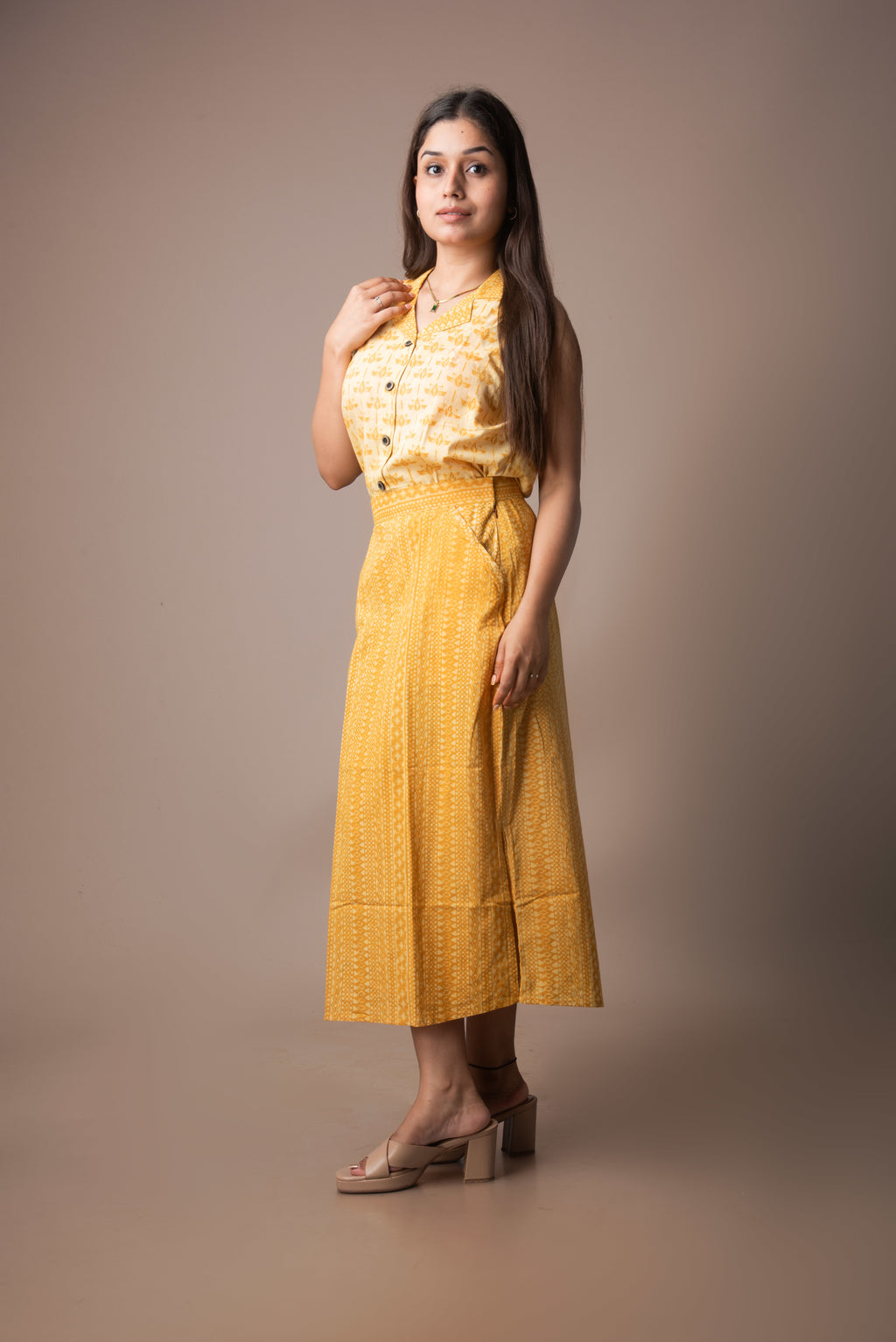 Woman wearing a yellow outfit against a brown background
