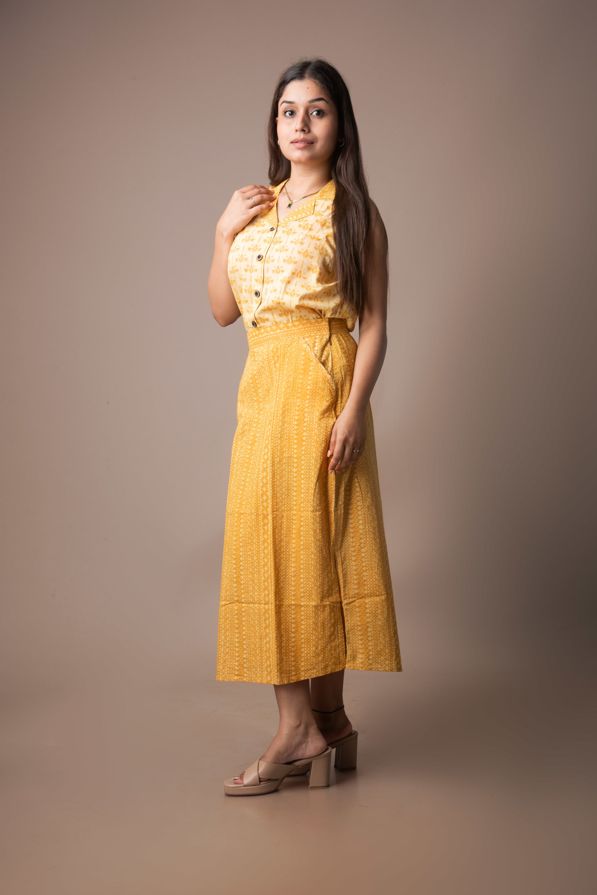 Woman wearing a yellow outfit against a brown background