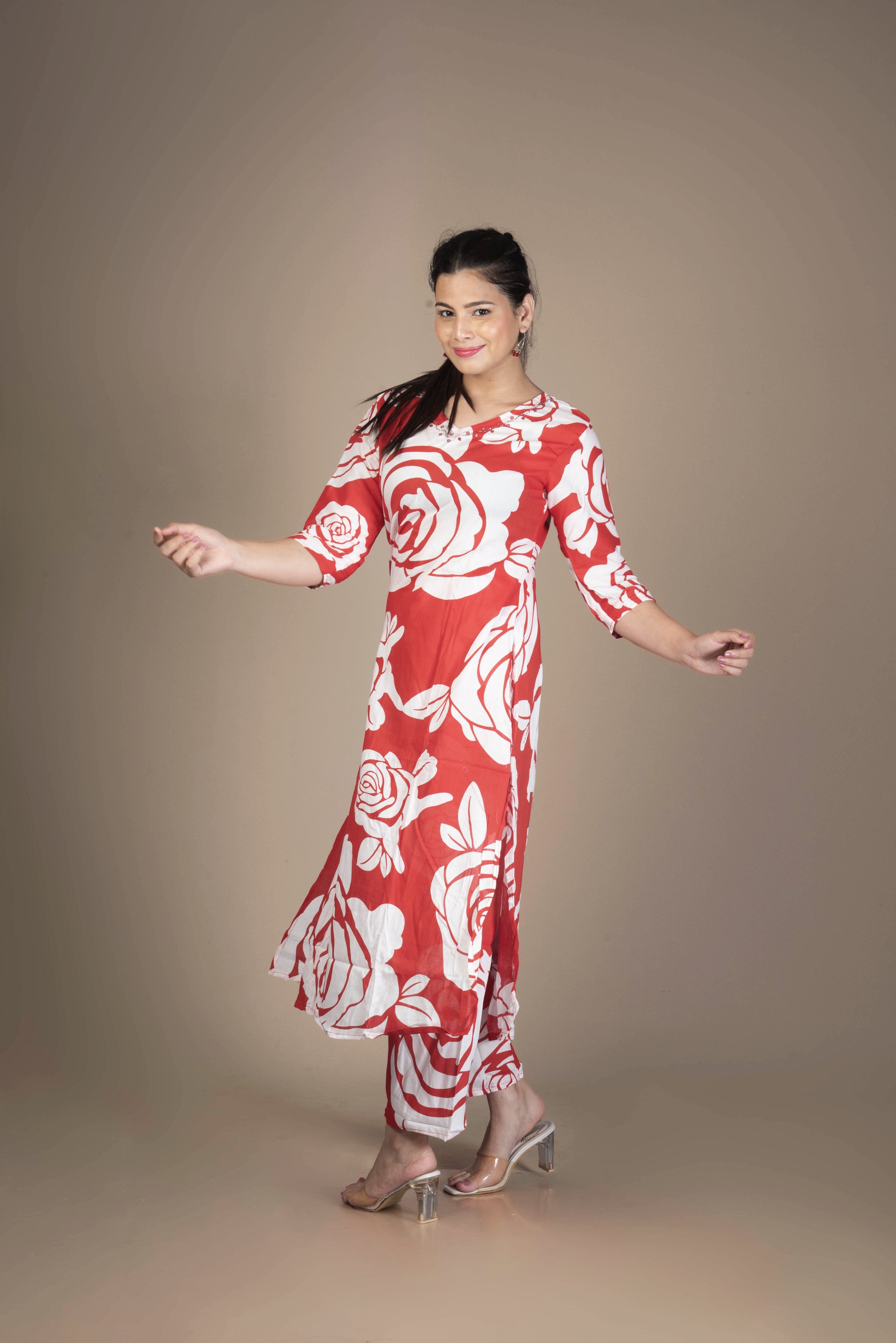 Woman wearing a red and white floral dress against a brown background