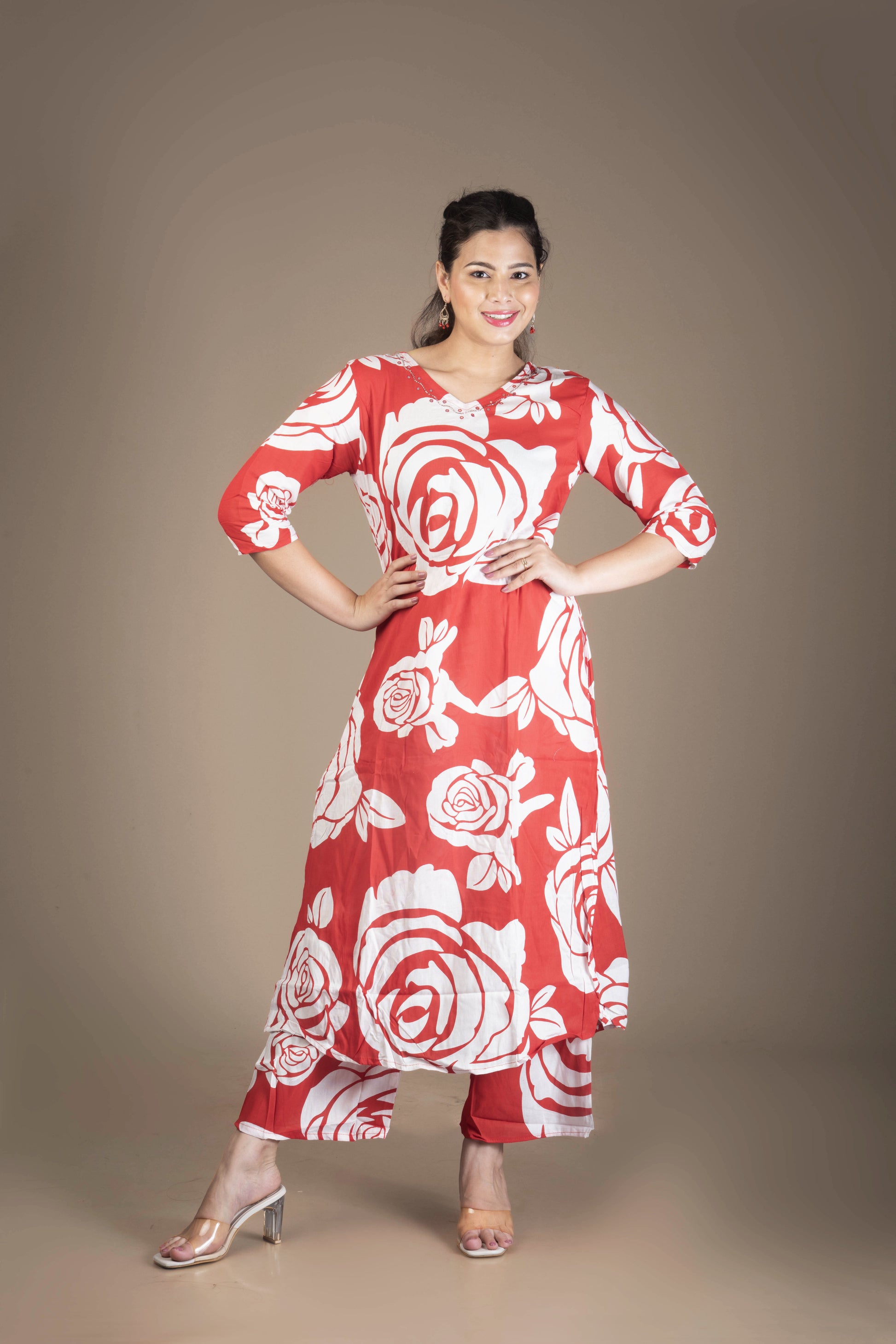 Woman wearing a red and white floral dress against a brown background