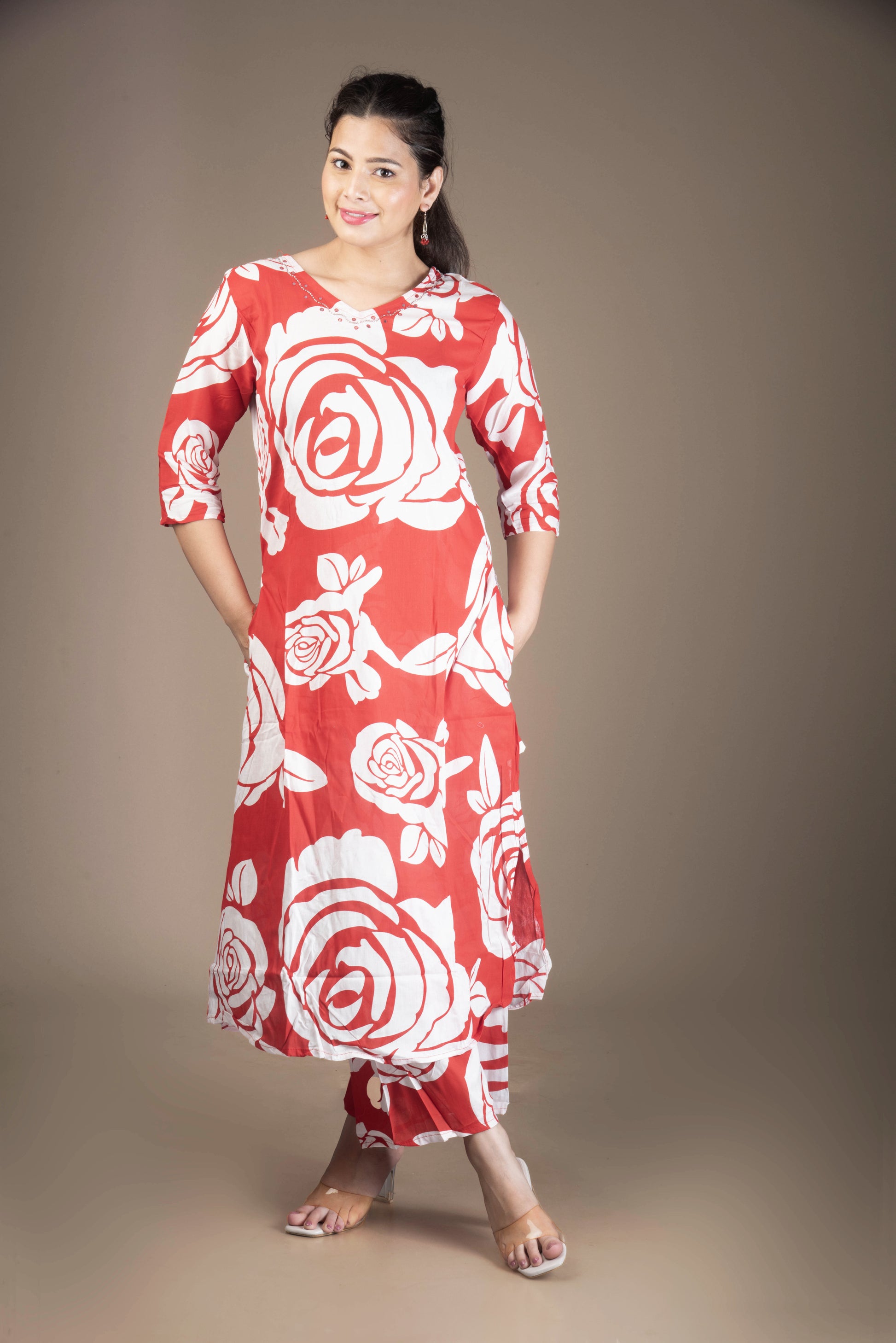 Woman wearing a red dress with white floral patterns on a brown background