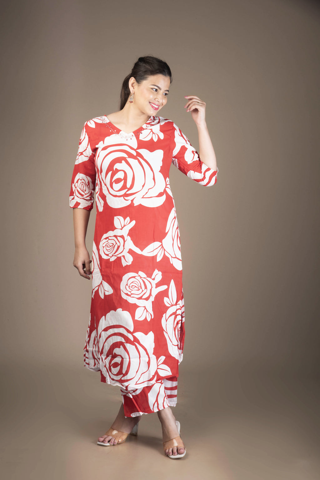 Woman wearing a red dress with white floral patterns on a brown background