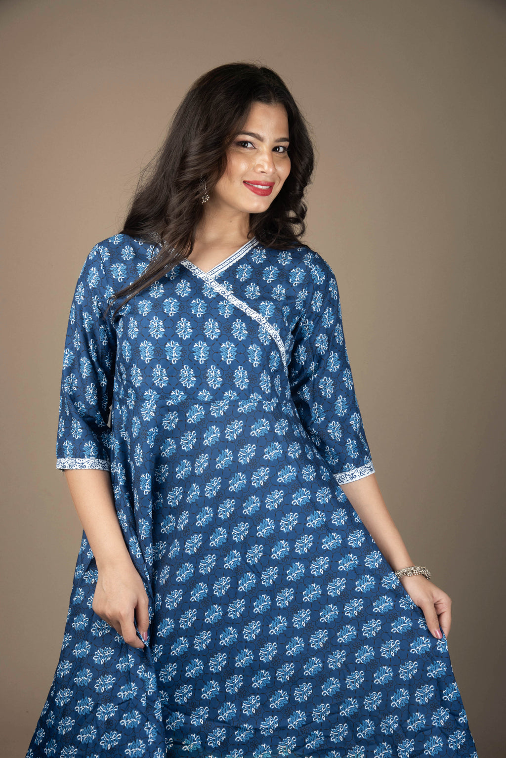 Woman wearing a blue patterned dress against a brown background