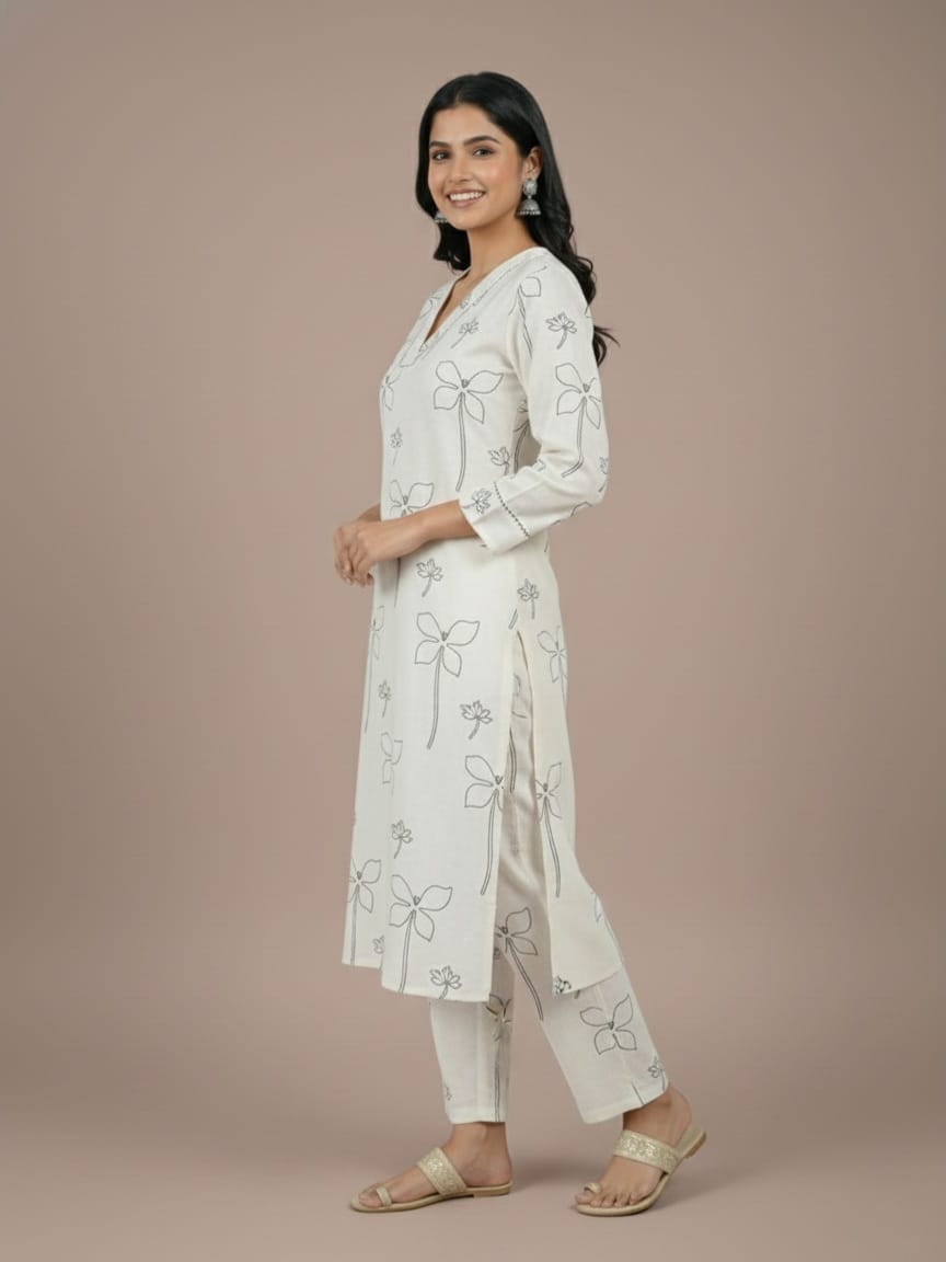 Woman wearing a white floral embroidered outfit on a beige background