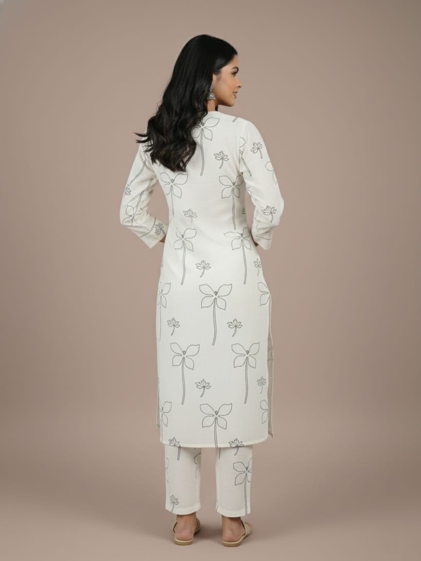 Woman wearing a white embroidered kurta with pants on a beige background