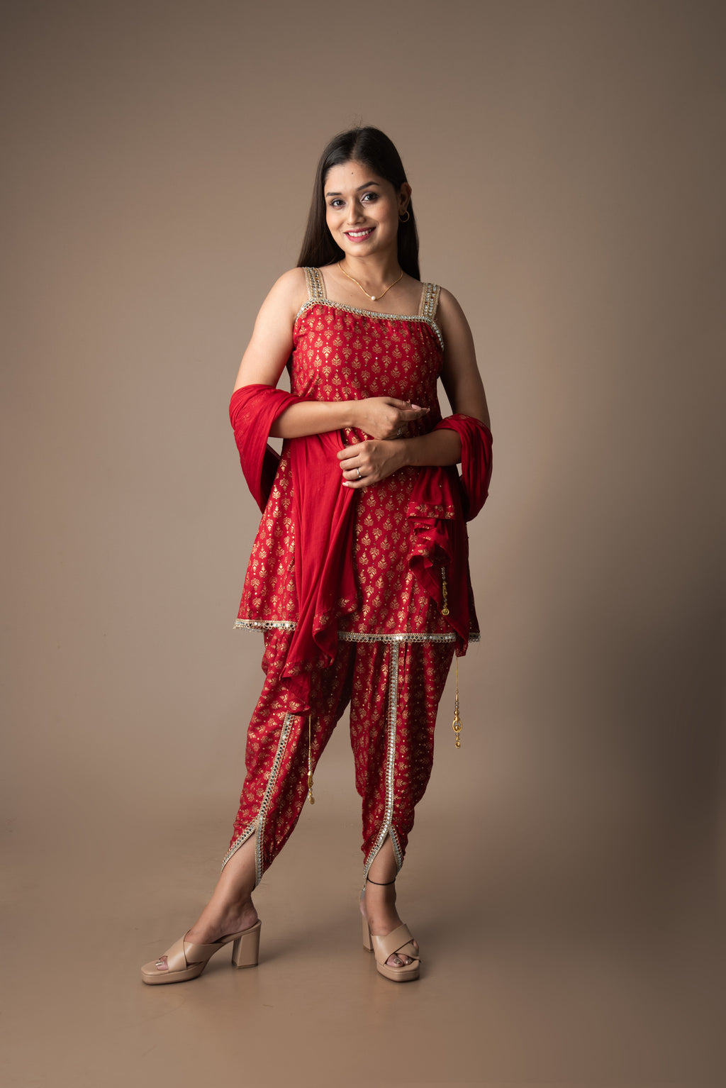 Woman in a red traditional outfit standing against a brown background