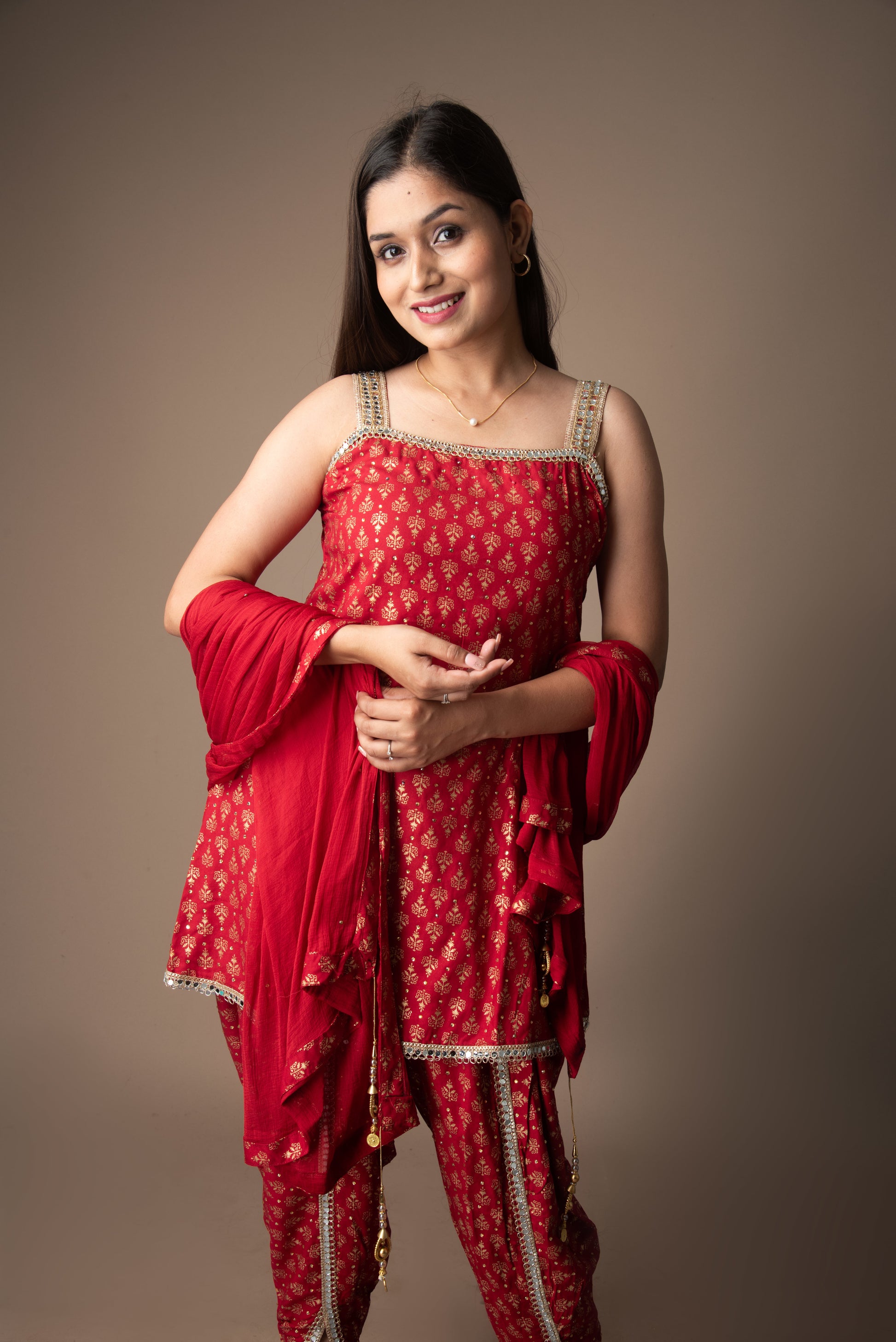 Woman wearing a red traditional outfit with gold patterns on a brown background
