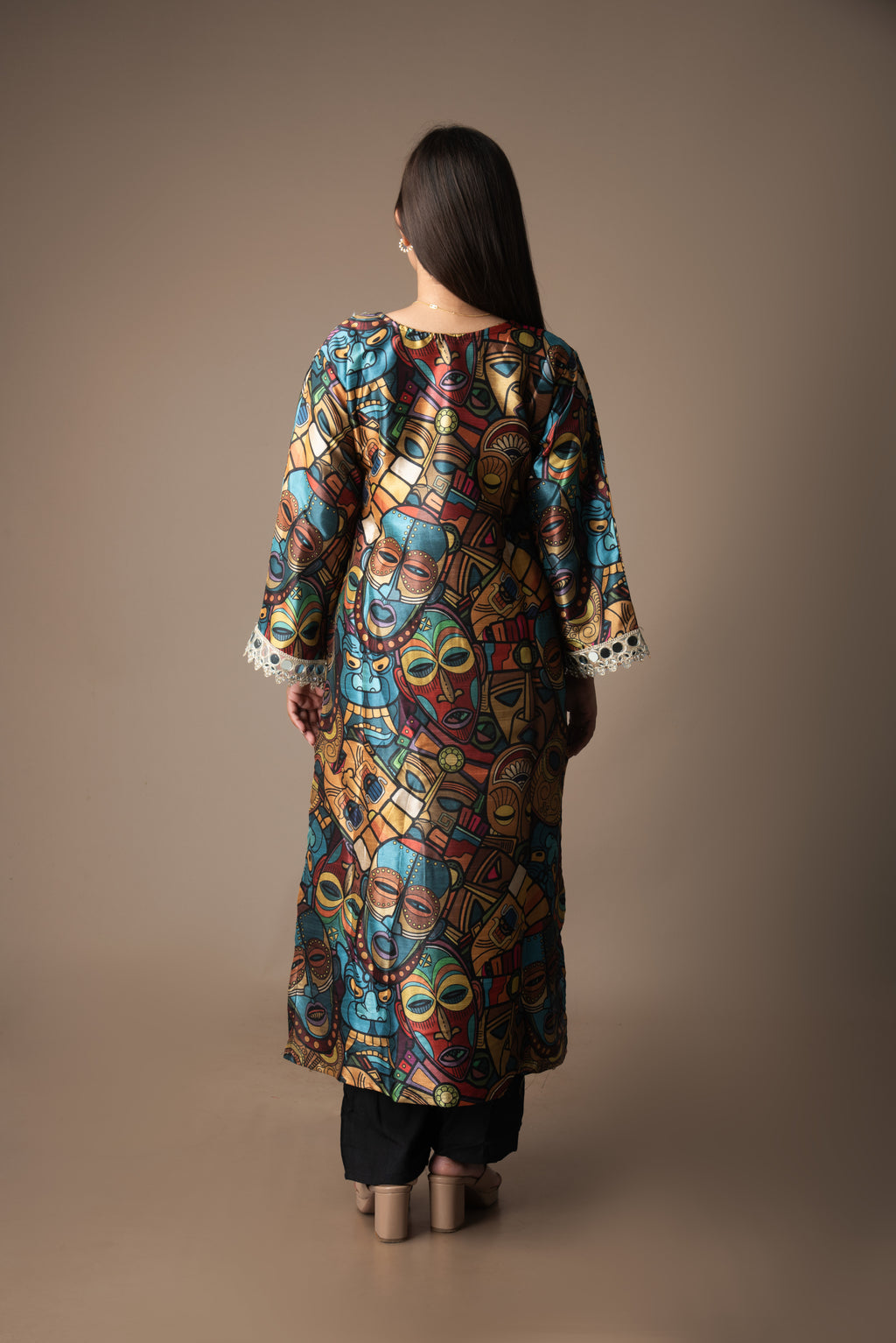 Woman wearing a colorful patterned dress against a brown background