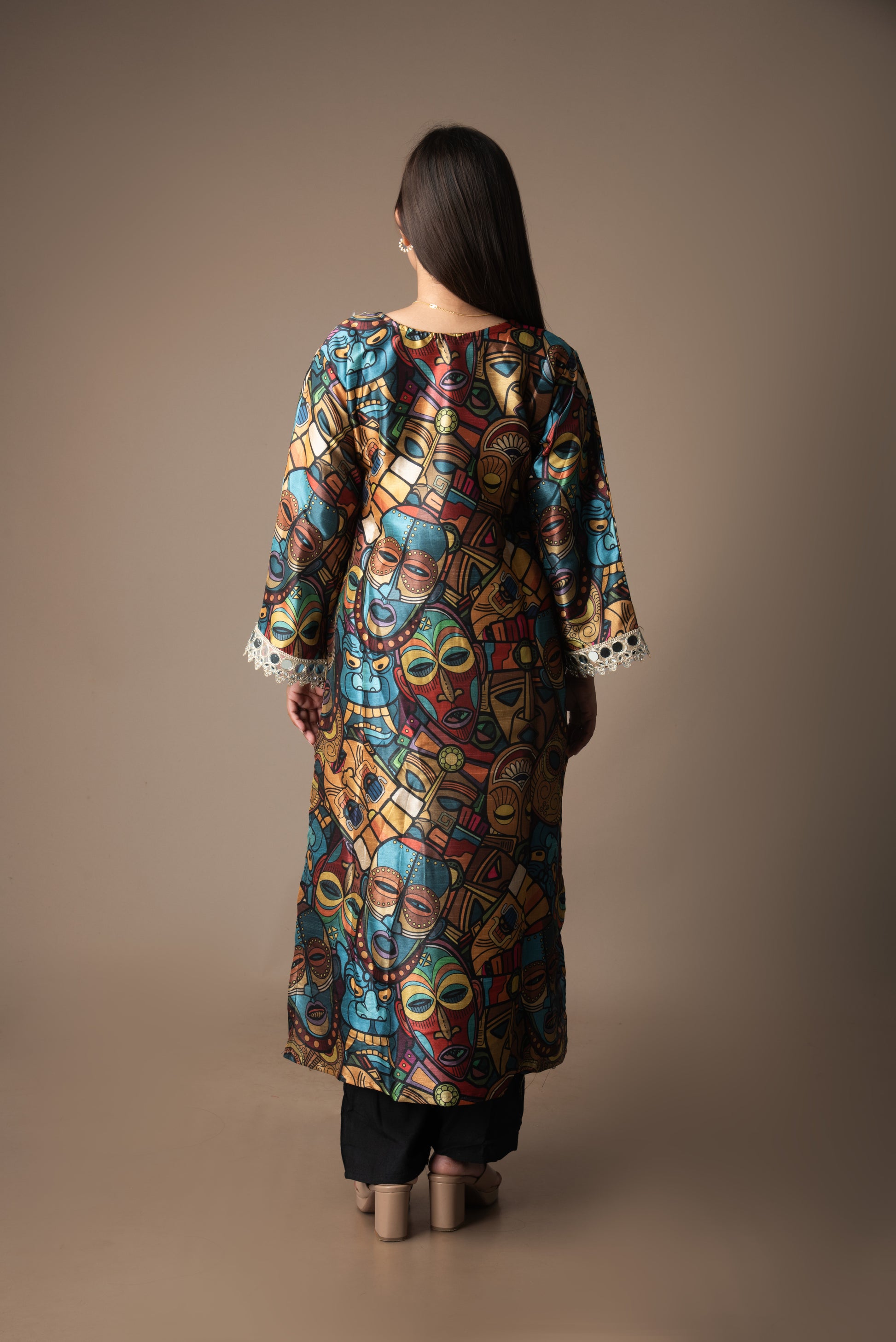 Woman wearing a colorful patterned dress against a brown background