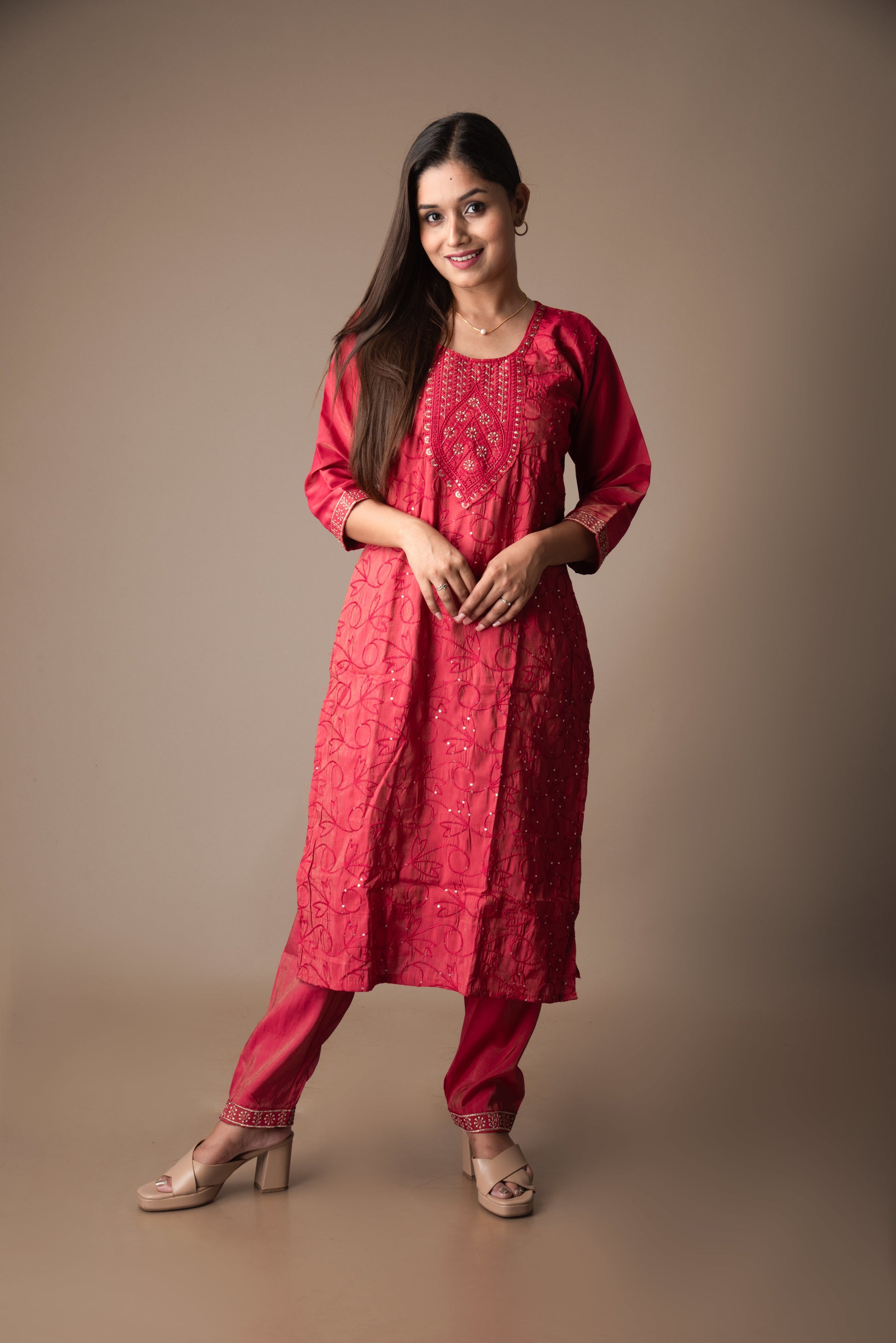 Woman wearing a red traditional outfit on a brown background