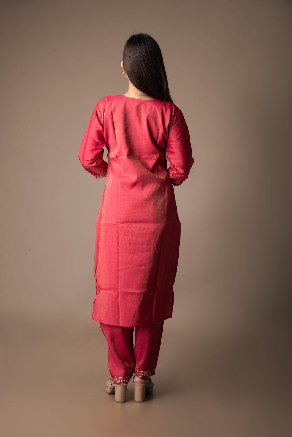 Woman wearing a red traditional outfit against a brown background