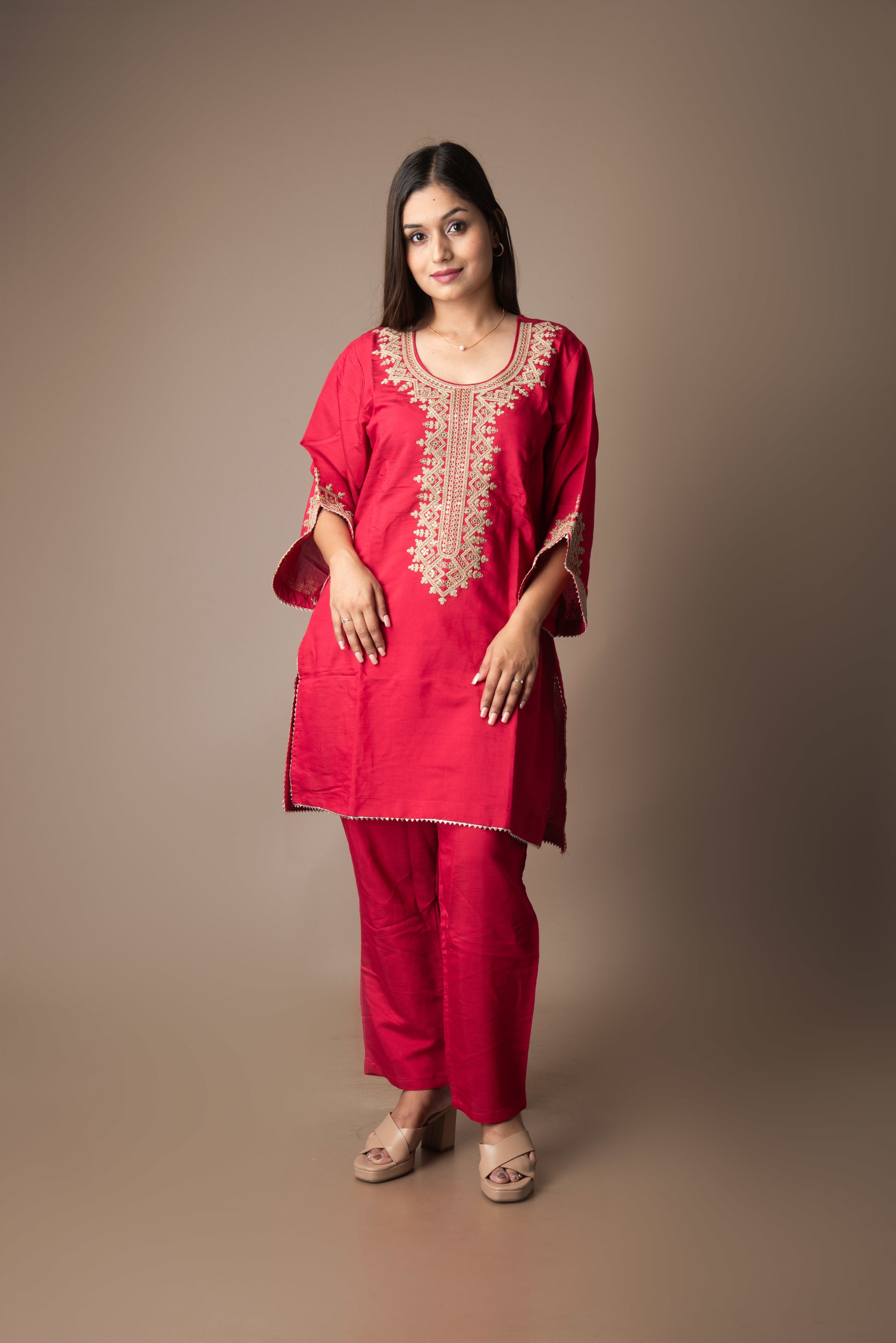 Woman wearing a red embroidered outfit on a beige background