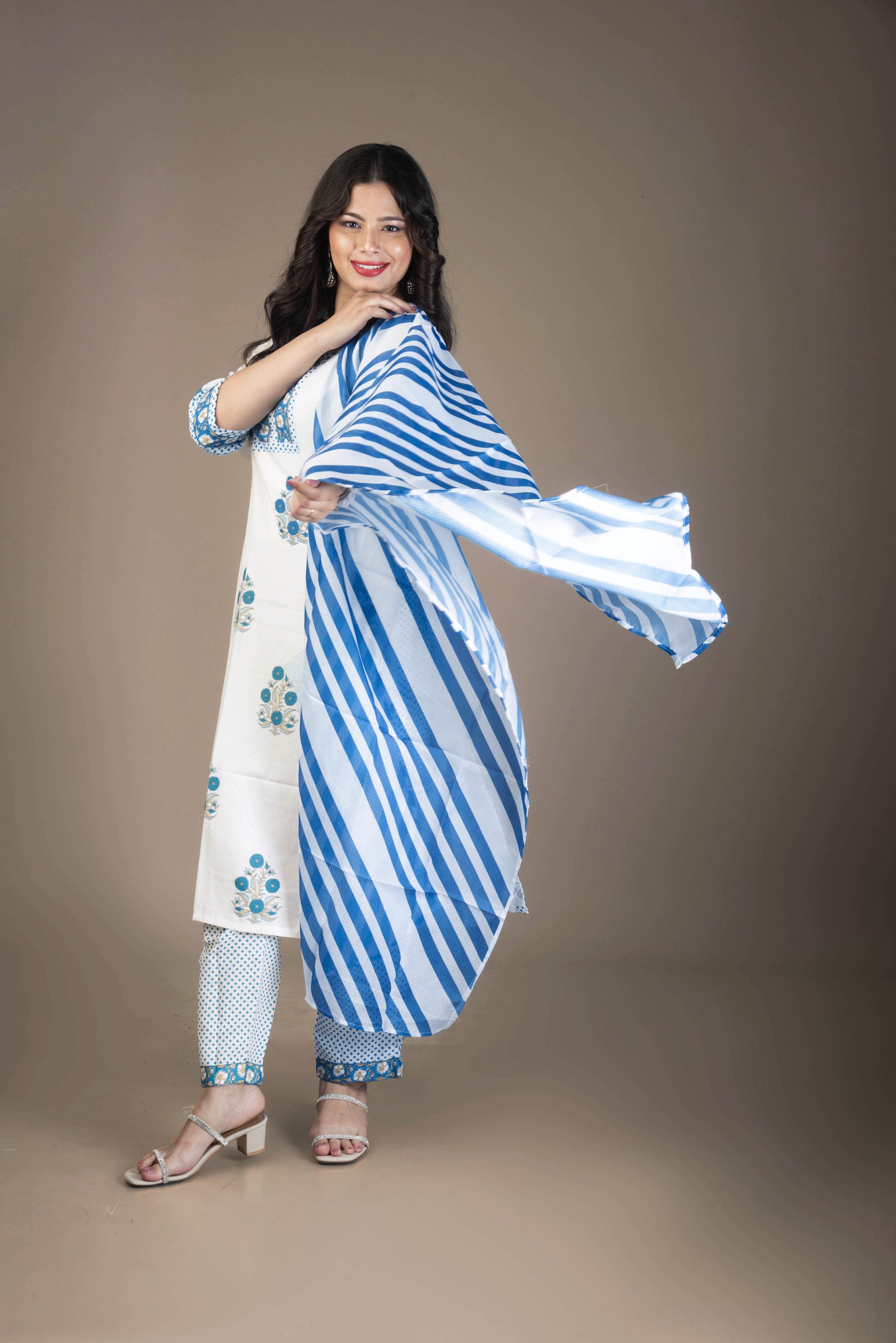 Woman wearing a white and blue striped outfit with floral patterns on a brown background