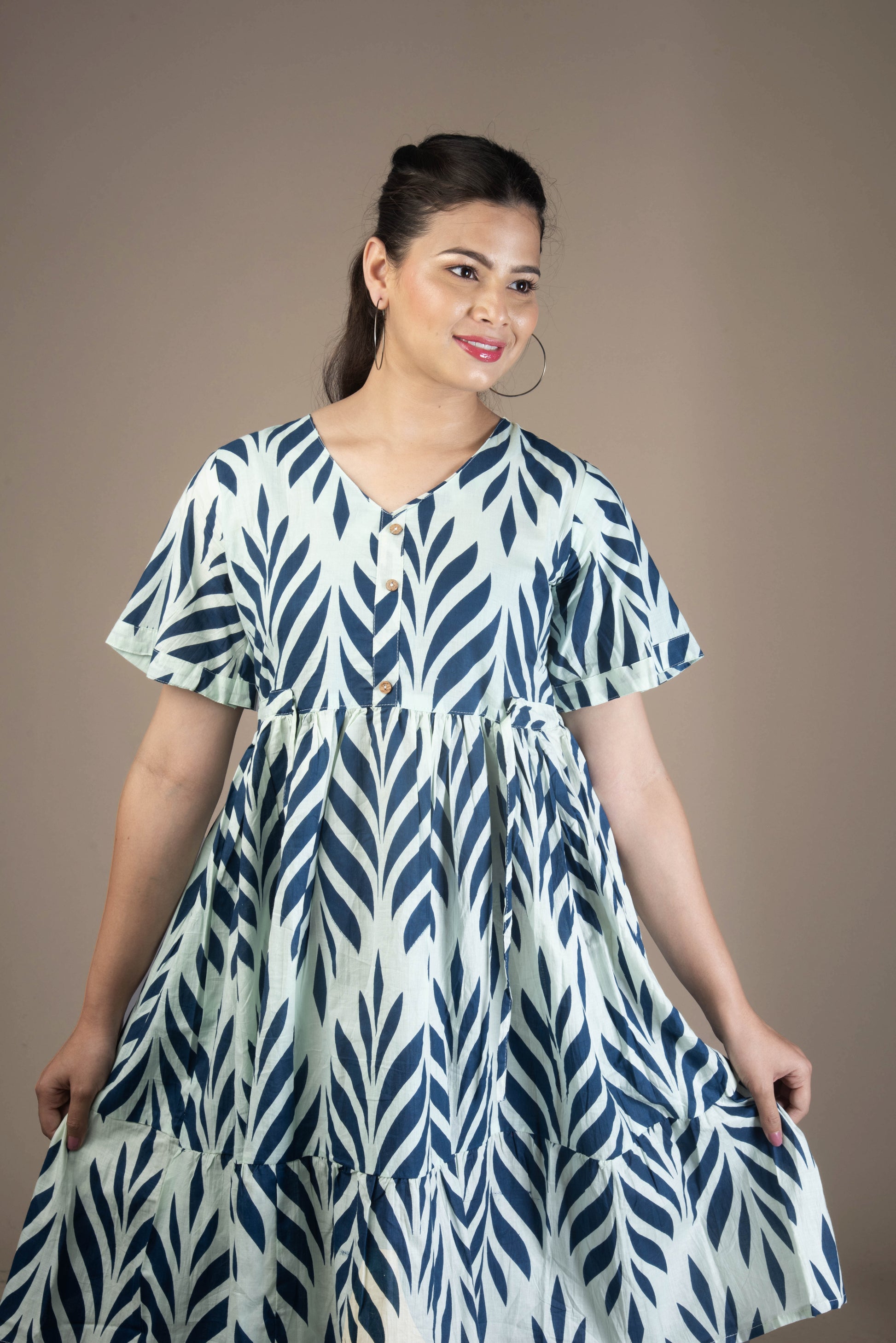 Woman wearing a blue and white patterned dress against a brown background