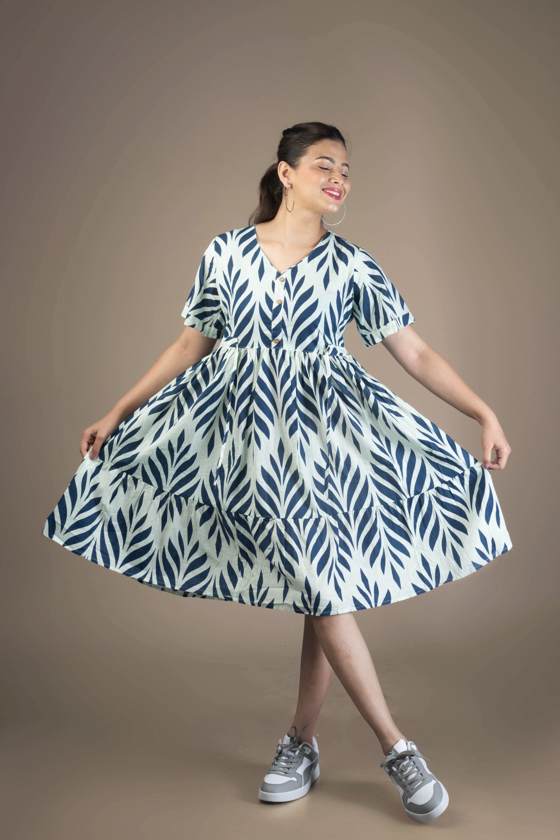Woman wearing a blue and white patterned dress on a brown background
