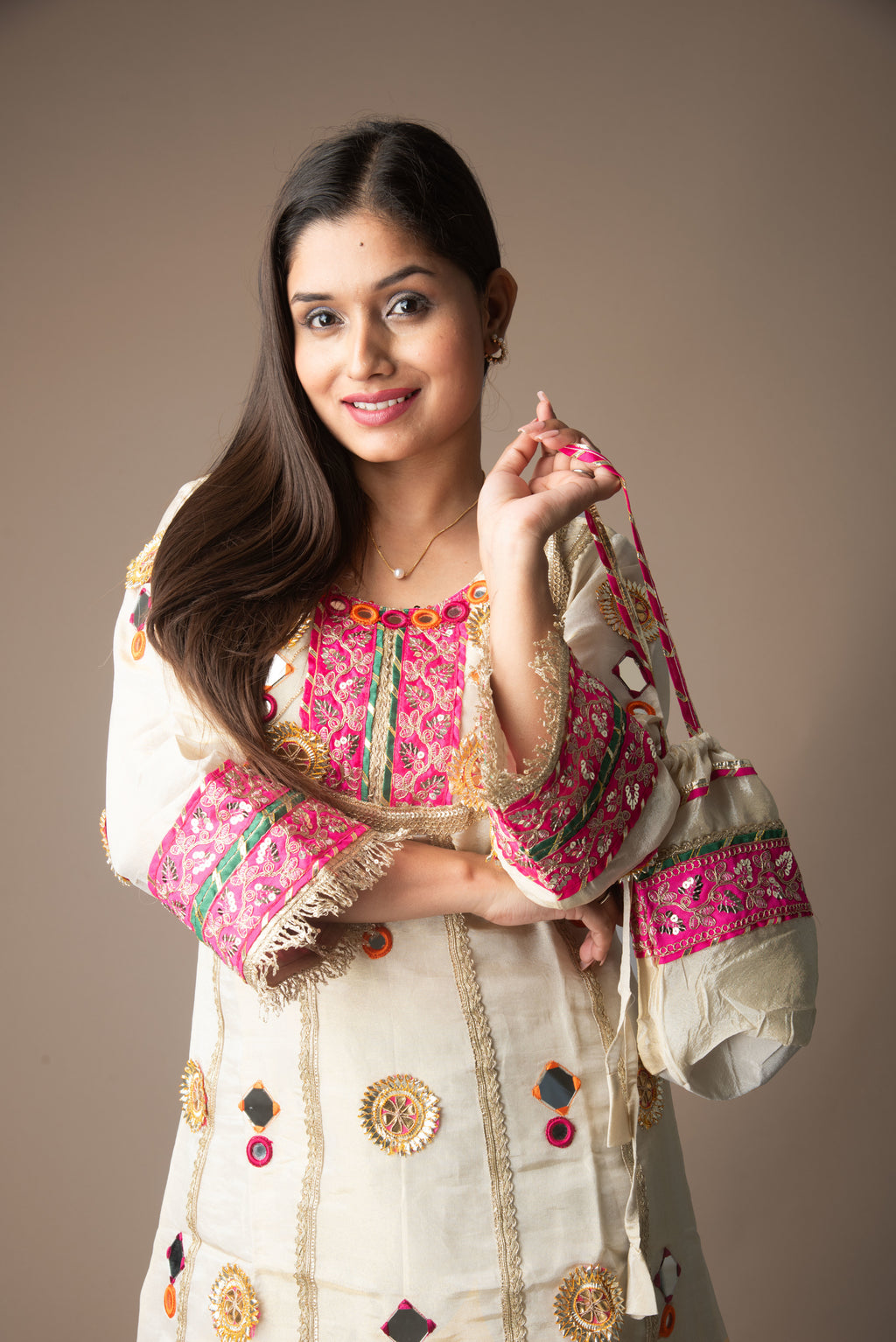 Woman holding a traditional embroidered bag against a plain background