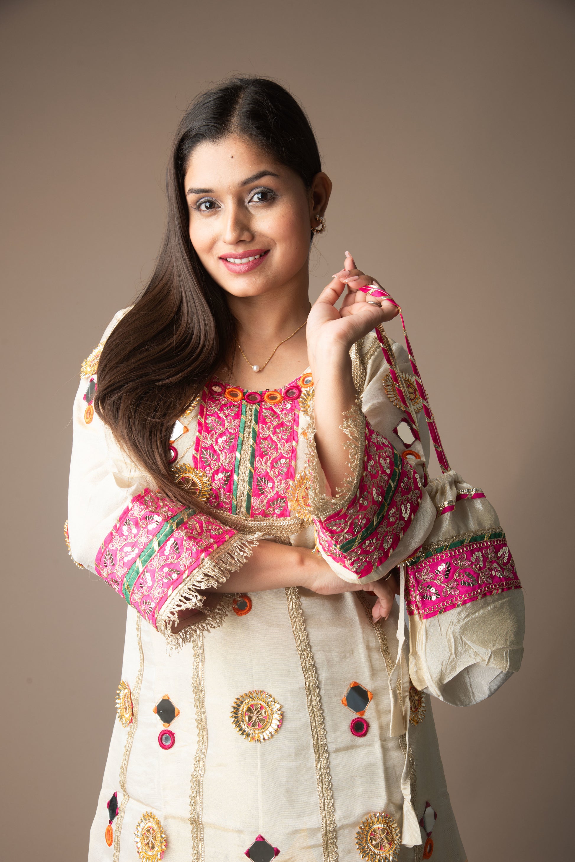Woman holding a traditional embroidered bag against a plain background