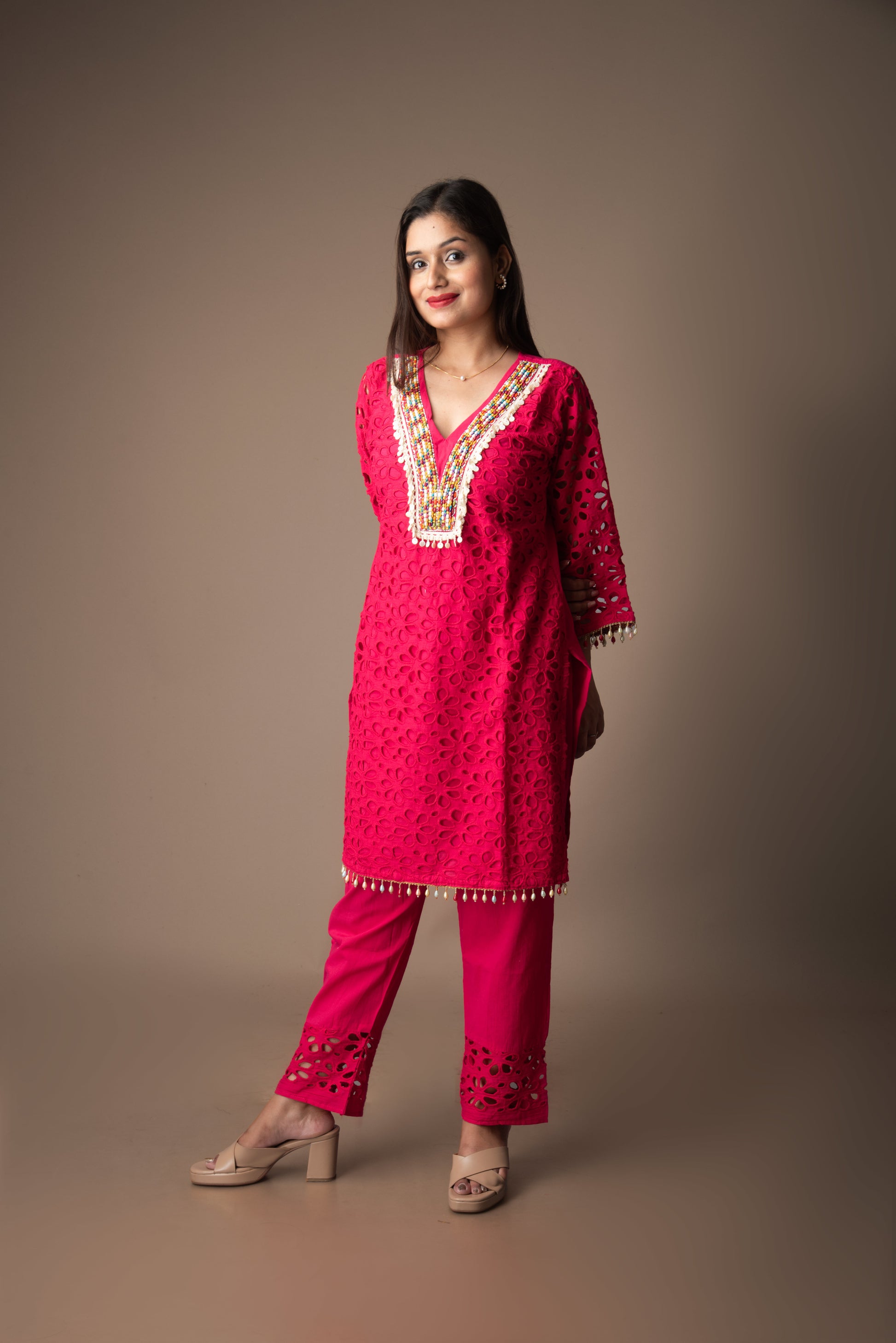 Woman wearing a red embroidered outfit on a brown background