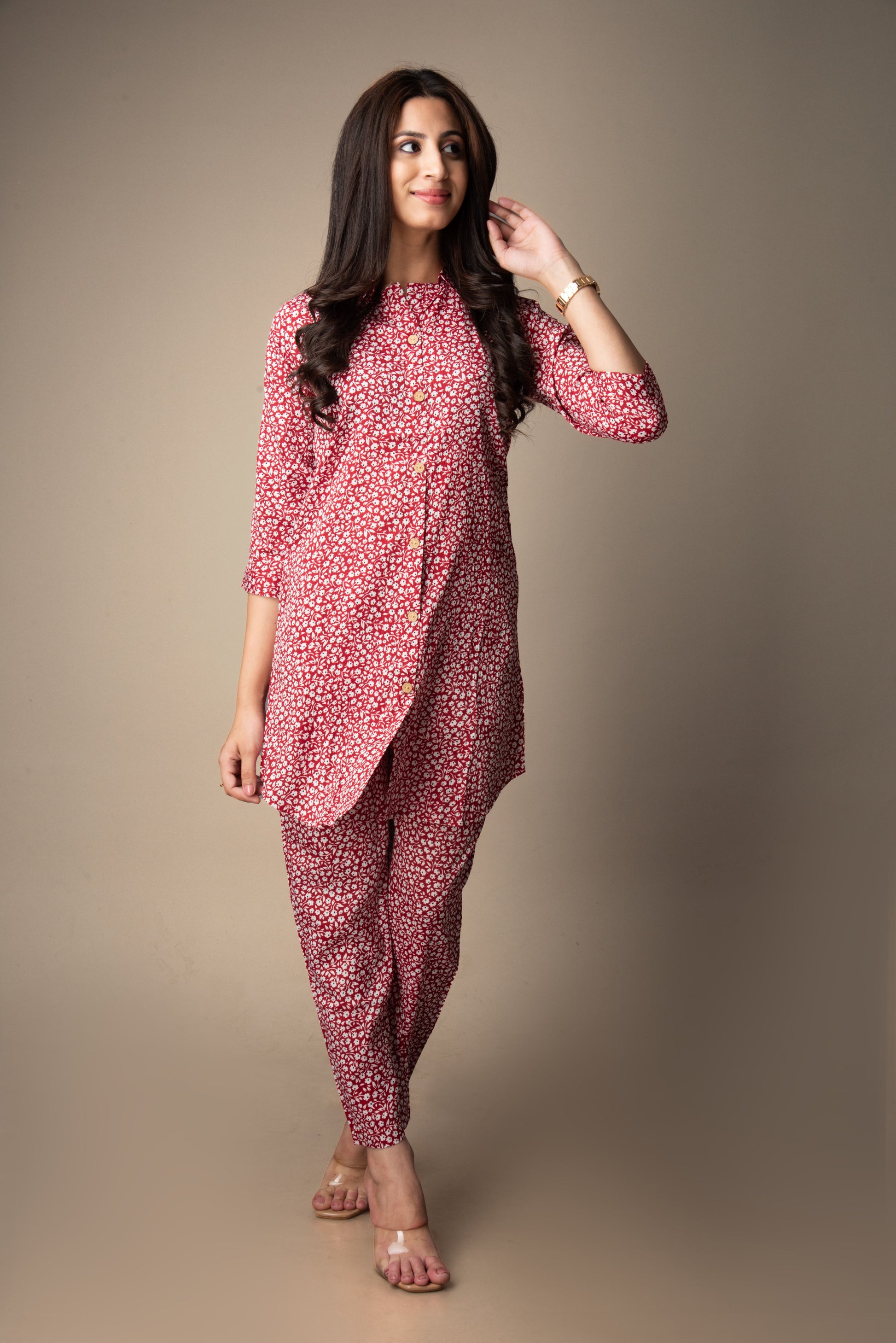 Woman wearing a pink floral outfit against a plain background